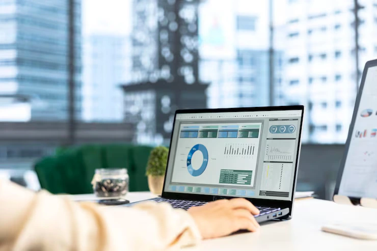 Woman pointing at a screen with graphs and data charts